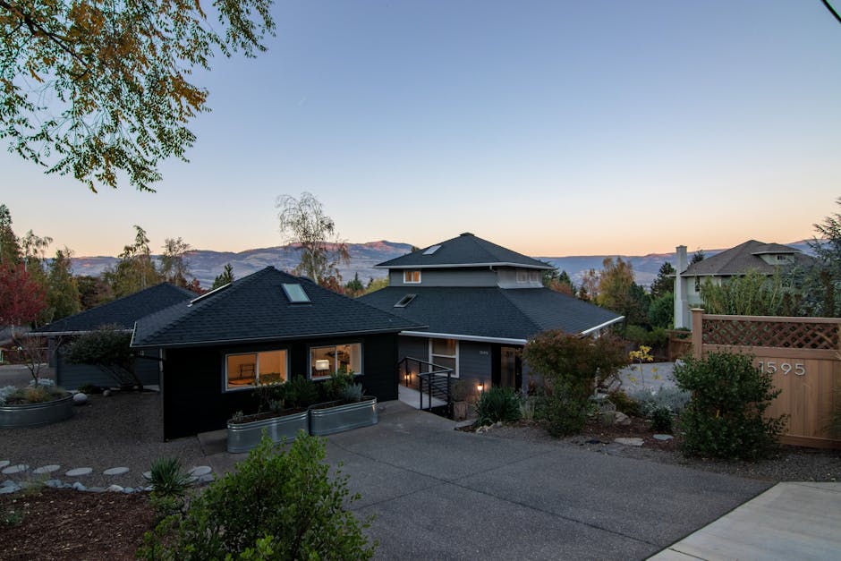 Elegant suburban house with spacious driveway and stunning mountain views at sunset.